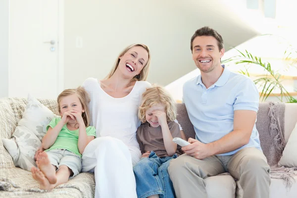 Семья смеется на диване — стоковое фото