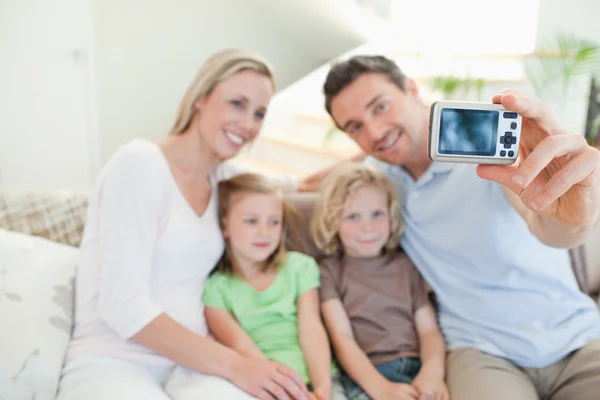 Pai tirando foto de família no sofá — Fotografia de Stock