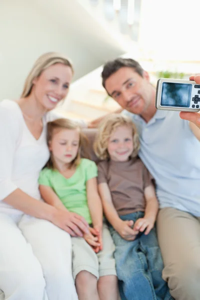 Мужчина фотографирует семью на диване — стоковое фото