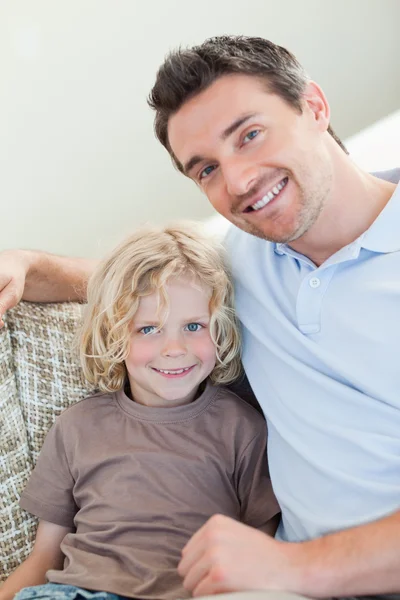 Father and son sitting on sofa — Stock Photo, Image
