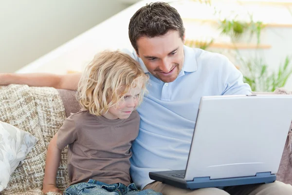 Vader en zoon met laptop op de Bank — Stockfoto