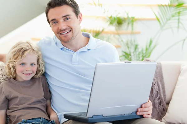 Vader en zoon op Bank met laptop — Stockfoto