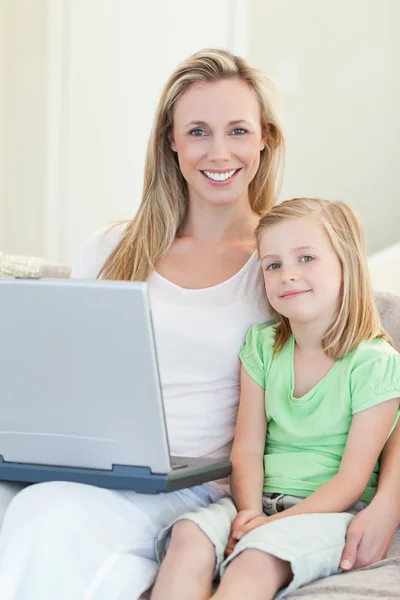 Mère et fille avec ordinateur portable sur canapé — Photo