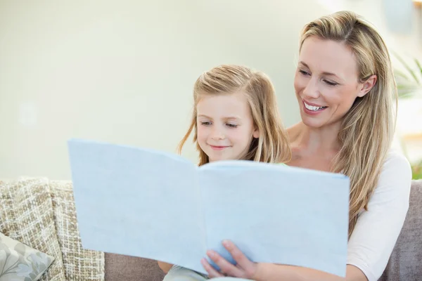 Mother and daughter reading on the couch — Stock Photo, Image