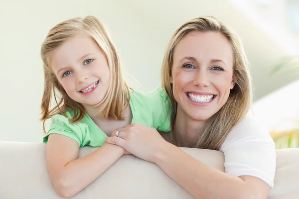 Sorrindo mãe e filha no sofá — Fotografia de Stock