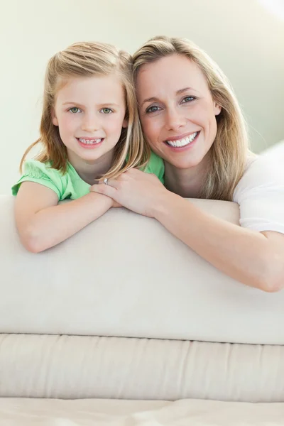 快乐微笑着母亲和女儿在沙发上 — 图库照片