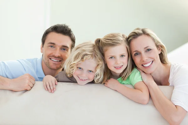 Улыбающаяся семья на диване — стоковое фото