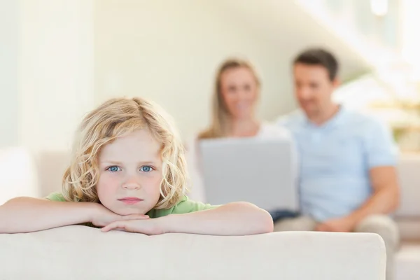 Sad boy with parents in the background — Stock Photo, Image