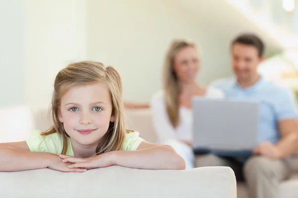 Smiling girl with parents behind her — Stock Photo, Image
