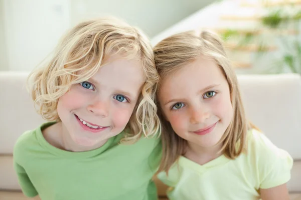 Usmívající se sourozenci na pohovce — Stock fotografie
