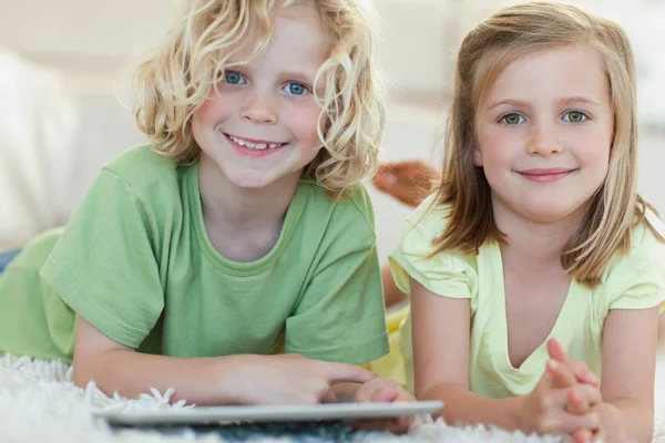 Siblings using tablet on the floor — Stock Photo, Image