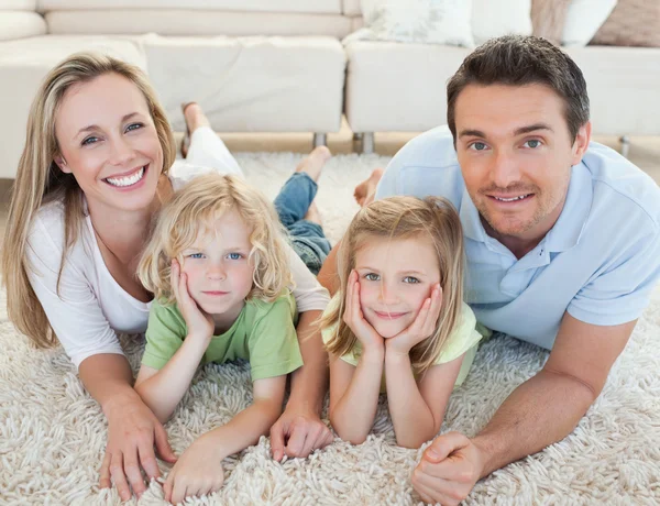 Familie liggen op het tapijt — Stockfoto