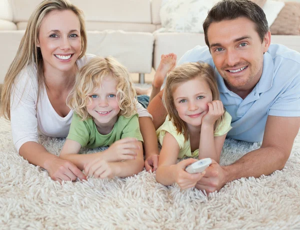 Família assistindo tv no chão — Fotografia de Stock