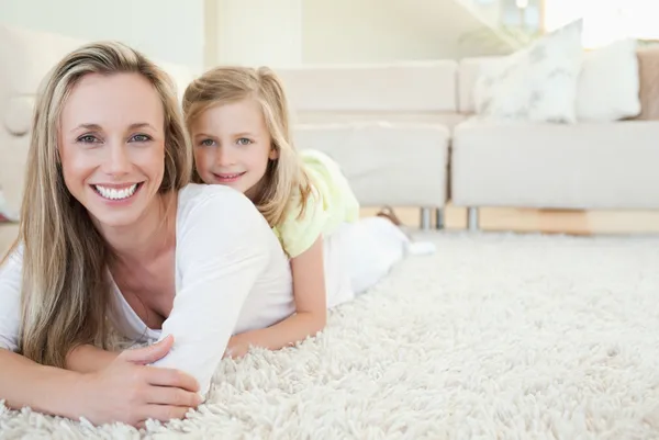 Mother and daughter lying on the floor — Stock Photo, Image