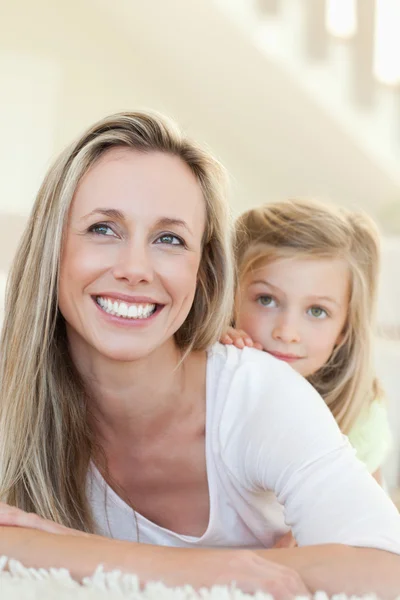 Smiling mother and daughter on the floor — Stock Photo, Image