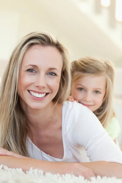 Anne ve kızı halı üzerinde gülümseyen — Stok fotoğraf
