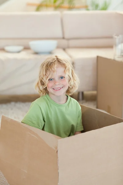Chłopiec ukrywa się w tekturowym pudełku — Zdjęcie stockowe