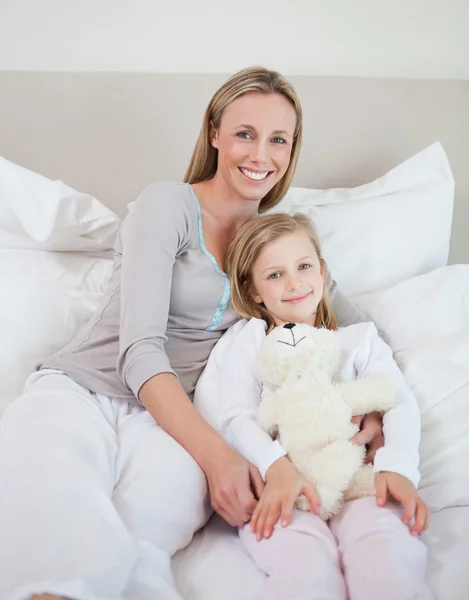 Mor och dotter sitter på sängen — Stockfoto
