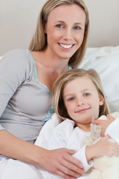Matka drží její dcera na postel — Stock fotografie