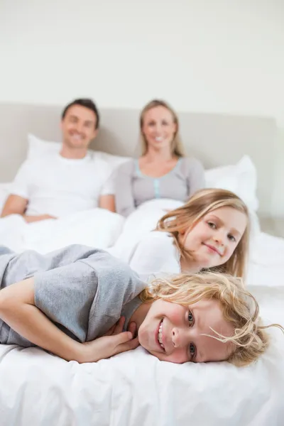 Семья отдыхает на кровати — стоковое фото