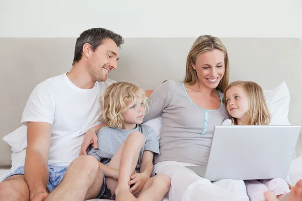 Familie met behulp van laptop op het bed — Stockfoto