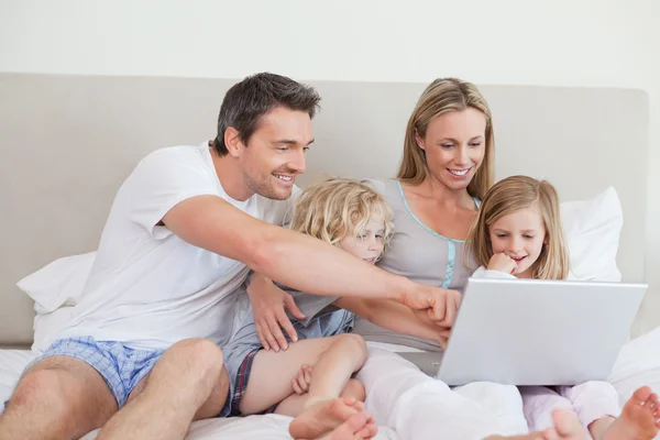 Family using notebook on the bed — Stock Photo, Image