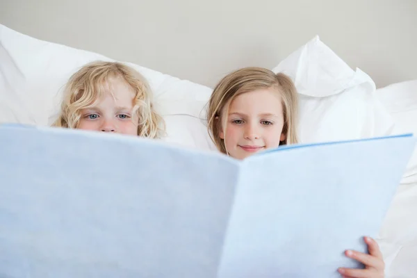 Rodzeństwo czytając bajkę na dobranoc — Zdjęcie stockowe