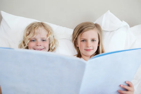 Irmão e irmã lendo história de dormir — Fotografia de Stock