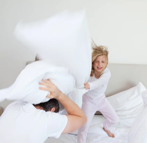 Девушка бьет своего отца подушкой — стоковое фото