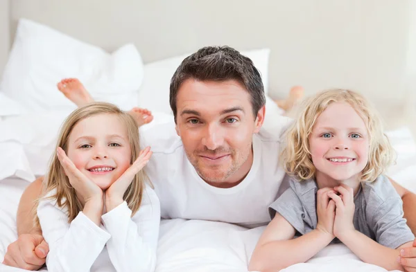 Otec ležel na posteli s jeho dětmi — Stock fotografie