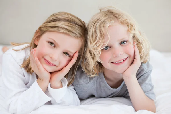 Brother and sister lying on the bed — Stock Photo, Image