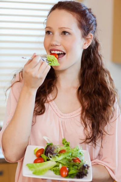 Frau isst Salat in der Küche — Stockfoto