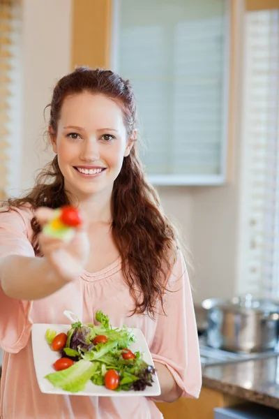 Smiling woman offering some salad — Stock Photo, Image