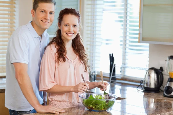 Couple with salad in the kitchen — Stock Photo, Image