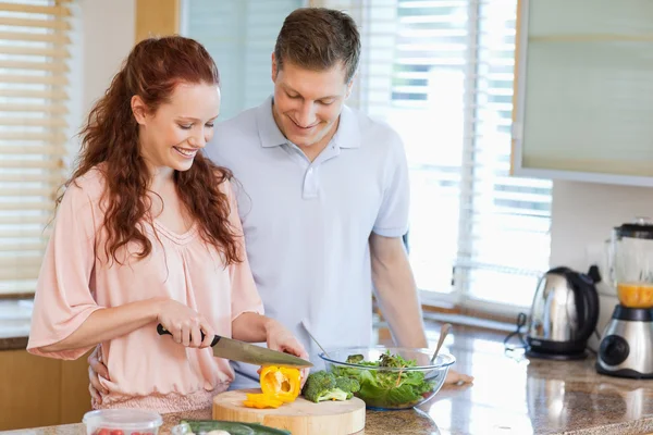 Мужчина смотрит, как его девушка готовит салат — стоковое фото