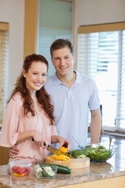 Masculino assistindo sua namorada preparando salada — Fotografia de Stock