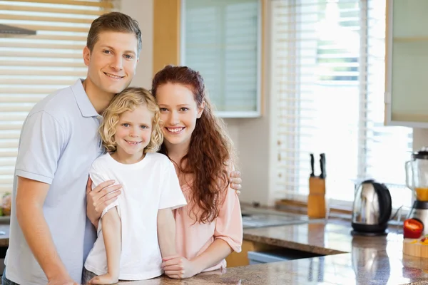 Улыбающаяся семья, стоящая за кухонным столом — стоковое фото