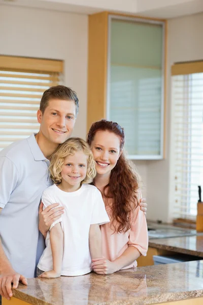 Веселая семья, стоящая за кухонным столом — стоковое фото