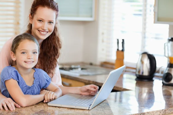 Mother and daughter surfing the internet in the kitchen — Stock Photo, Image