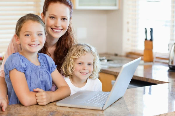 Μητέρα με τα παιδιά τους φορητό υπολογιστή στην κουζίνα — Φωτογραφία Αρχείου