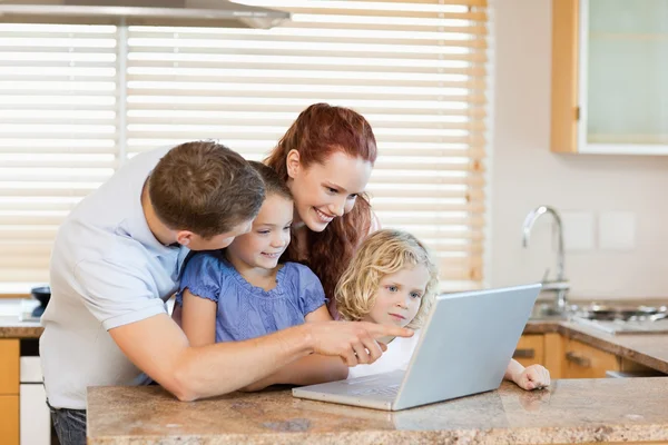 Семья с ноутбуком на кухне — стоковое фото