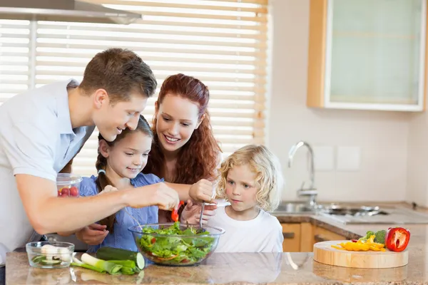 Familia preparando ensalada juntos — Foto de Stock