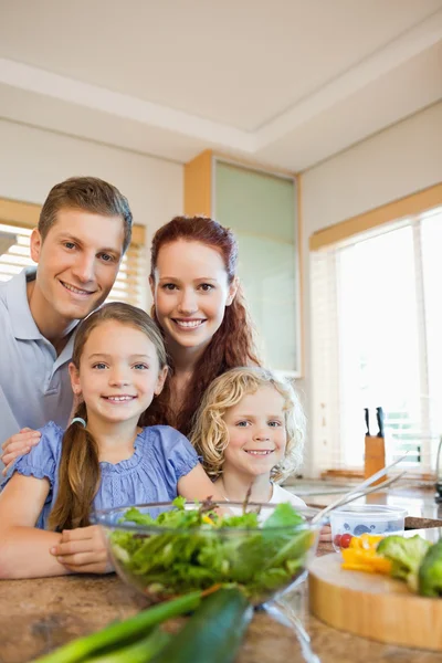 Young family standing behind the kitchen counter — Stock Photo, Image