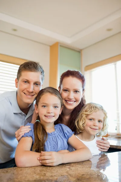 Happy family standing behind the kitchen counter — Stock Photo, Image
