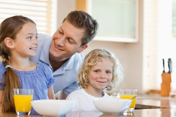 Padre con i suoi figli dietro il bancone della cucina — Foto Stock