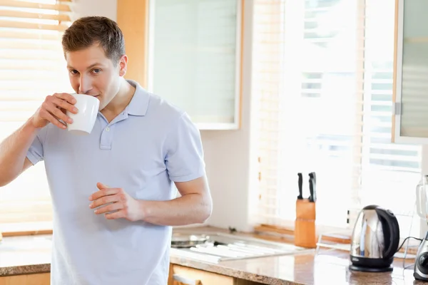 Hombre tomando un sorbo de café en la cocina — Foto de Stock