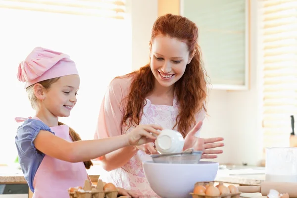 Smiling mother and daughter preparing dough — Stock Photo, Image