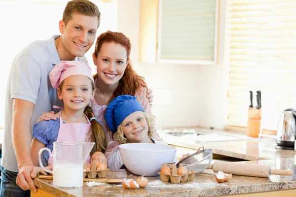 Family with baking ingredients behind the kitchen counter — Stock Photo, Image