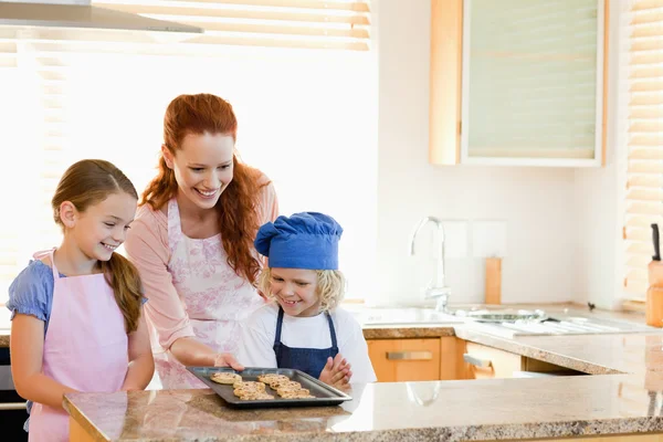 母彼女の子供たちに完成したクッキーを提示します。 — ストック写真