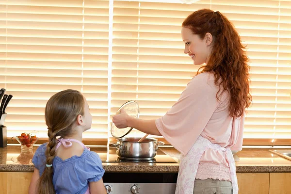 Madre enseñando a su hija lo que cocina — Foto de Stock